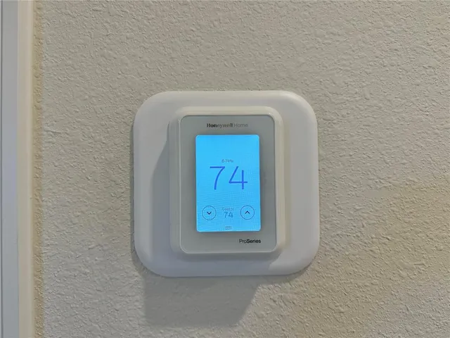 a view of kitchen with kitchen island stainless steel appliances refrigerator stove microwave and white cabinets