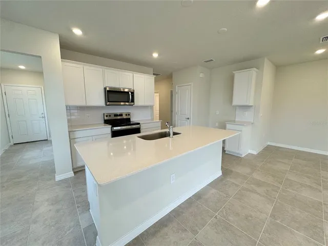 a large white kitchen with a large counter top
