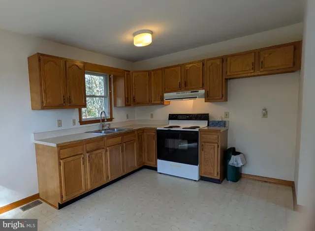 a kitchen with stainless steel appliances granite countertop a stove a sink and a refrigerator