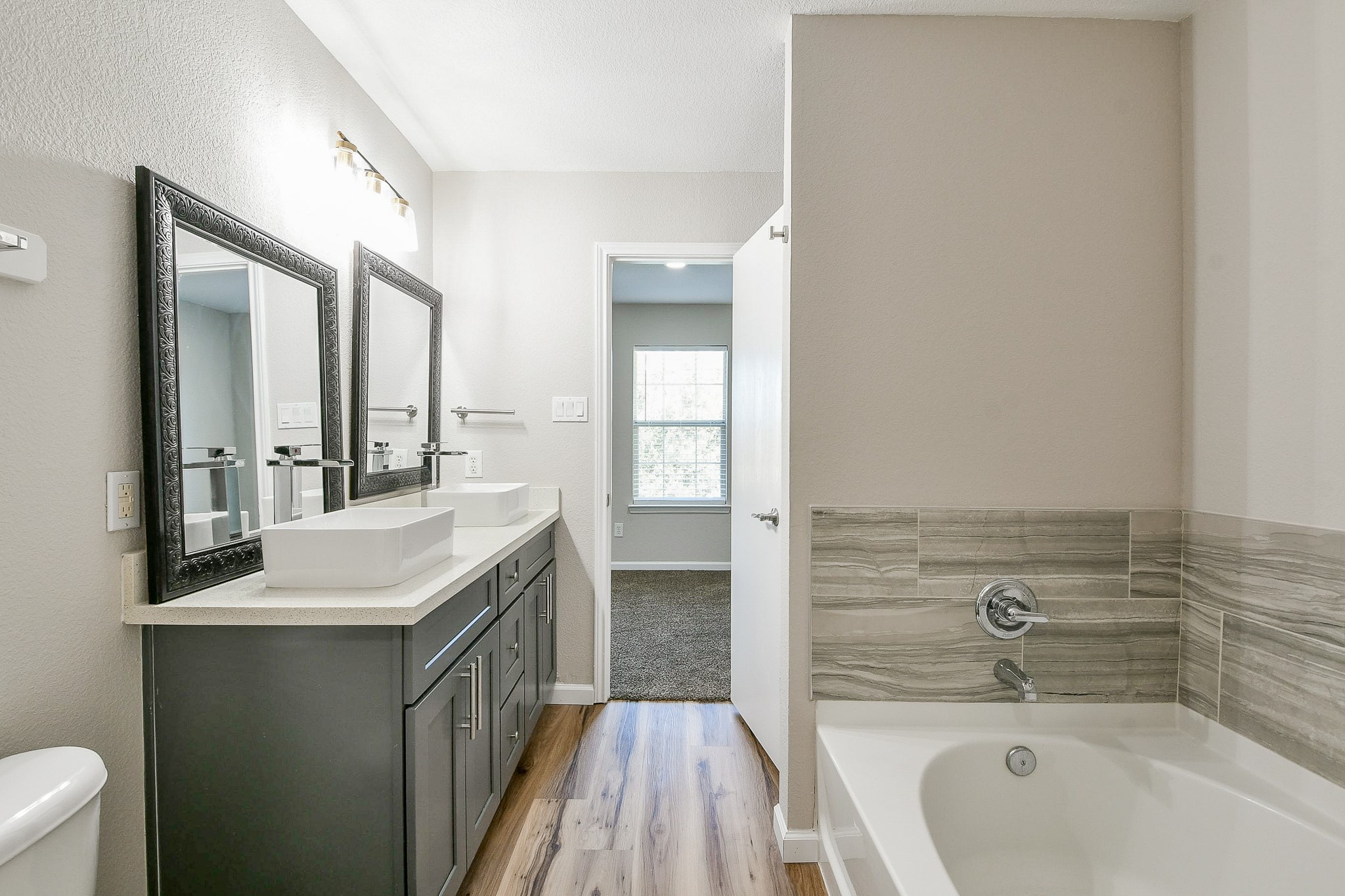 20807 Lansing Ridge Lane Katy, TX 77449 - Photo 27 of 35 a bathroom with a granite countertop sink and a bathtub
