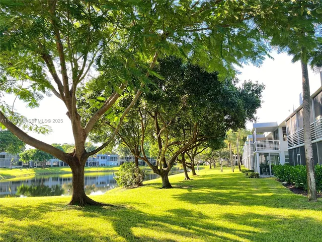 a view of a swimming pool with a garden and trees