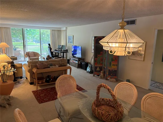 a living room with furniture a window and a chandelier