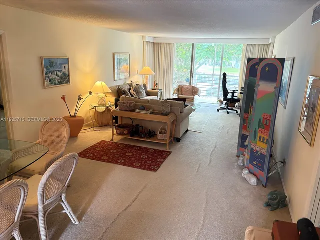 a living room with furniture a large window and a flat screen tv