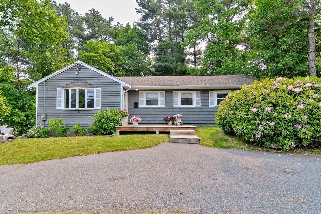 a front view of a house with yard and green space