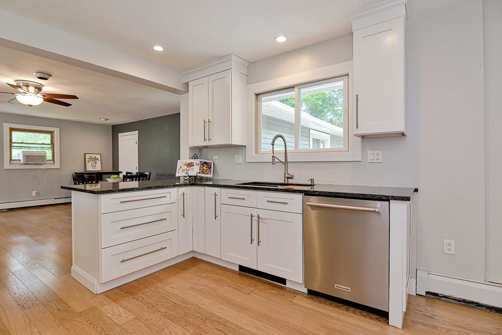 211 Beacon Street Framingham, MA 01701 - Photo 15 of 42 a kitchen with granite countertop white cabinets and white appliances
