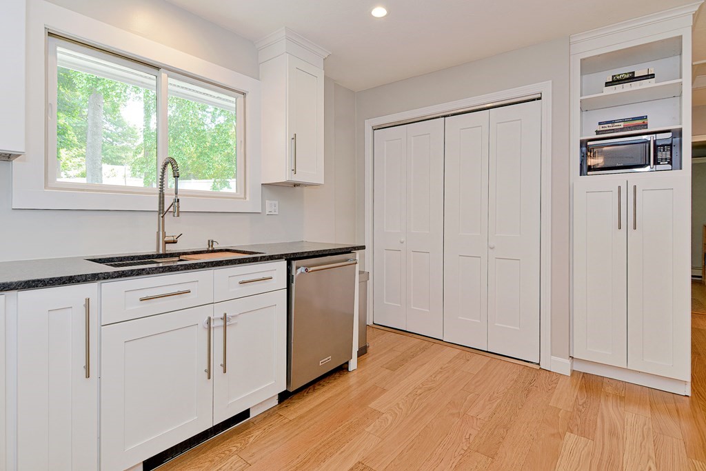 211 Beacon Street Framingham, MA 01701 - Photo 19 of 42 a kitchen with stainless steel appliances white cabinets and wooden floors