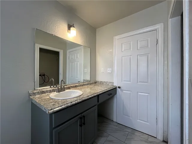 a bathroom with a granite countertop sink and a mirror