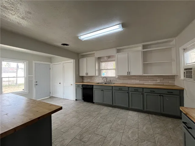 a large kitchen with granite countertop a sink and a stove