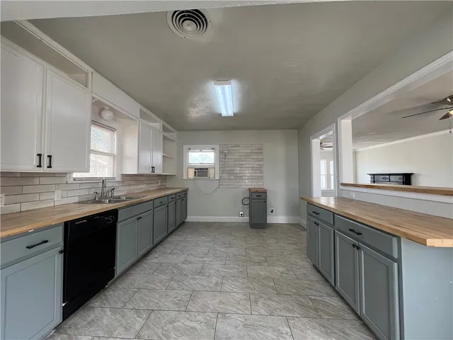 a large kitchen with a stove top oven sink and cabinets
