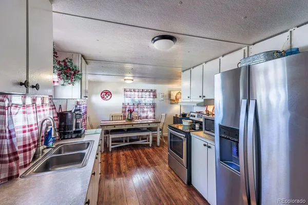 a kitchen with stainless steel appliances granite countertop a stove refrigerator and a sink