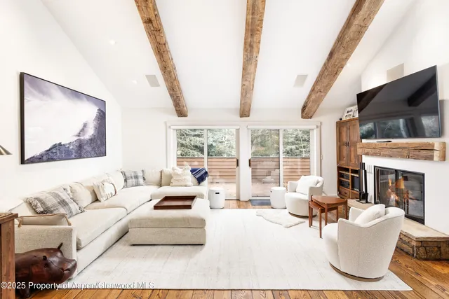 a living room with furniture large window and a flat screen tv