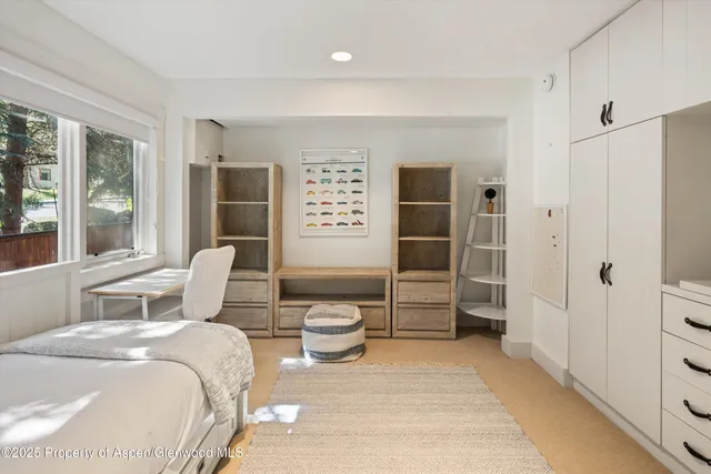 a bedroom with a bed and glass door