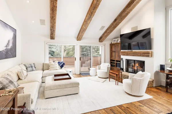 a living room with furniture large window and a fireplace