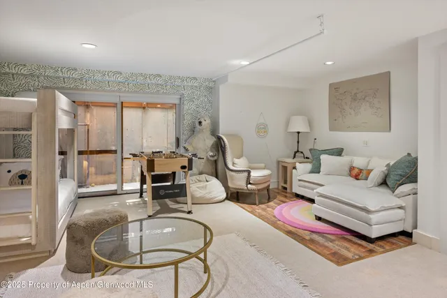 a living room with furniture chandelier and a fireplace