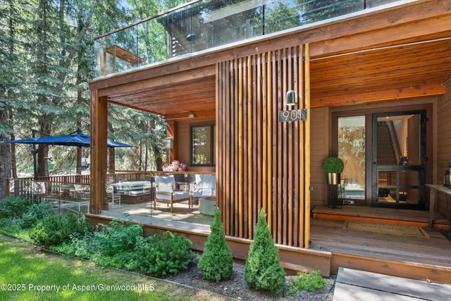 a view of a patio with a table and chairs and floor to ceiling window