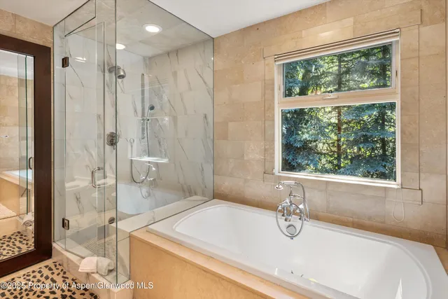 a bathroom with a tub a sink and a window