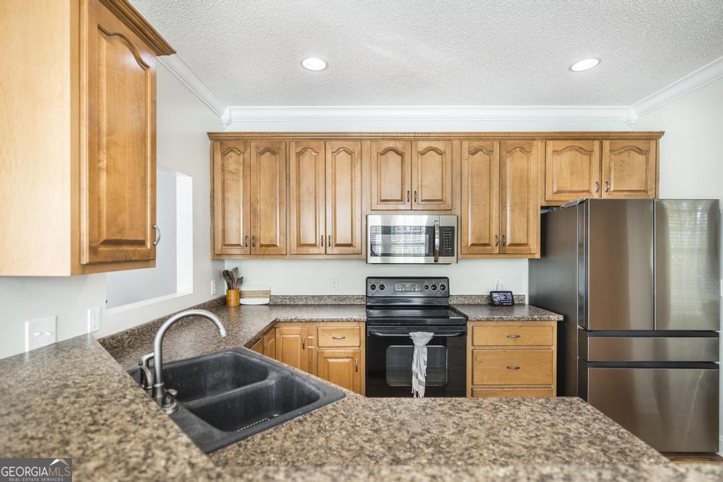 119 William D Street Cochran, GA 31014 - Photo 13 of 42 a kitchen with granite countertop a stove a sink and a refrigerator