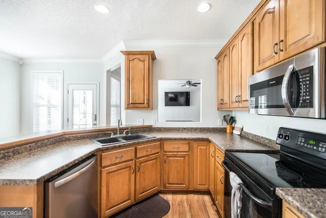 a kitchen with stainless steel appliances granite countertop a sink stove and cabinets