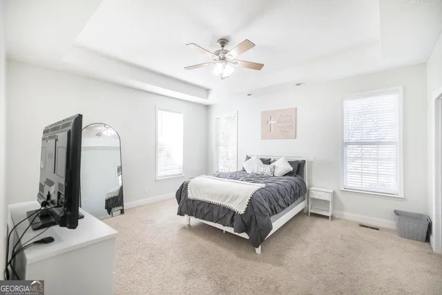 a spacious bedroom with a bed a window and a chandelier