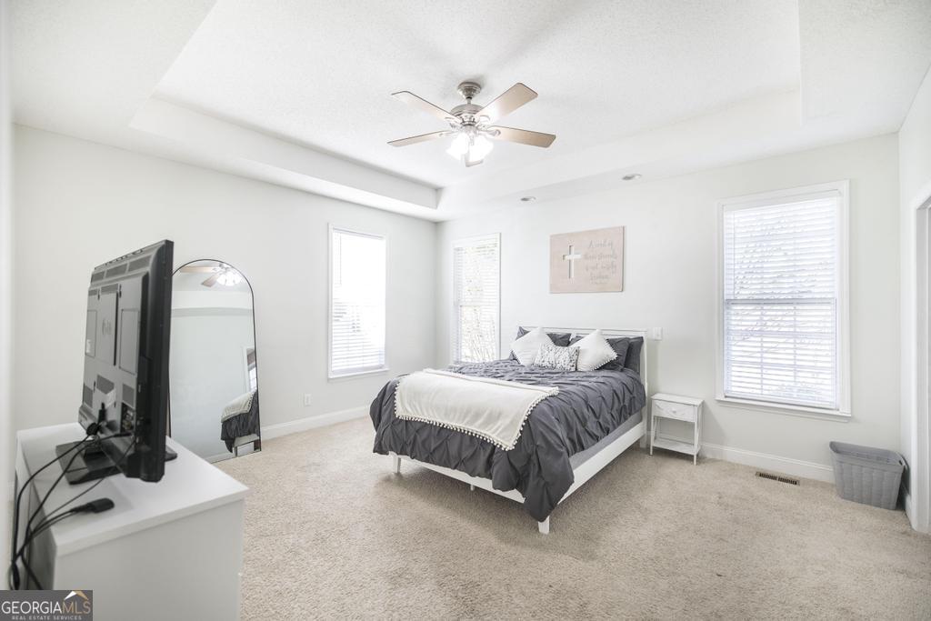 119 William D Street Cochran, GA 31014 - Photo 17 of 42 a spacious bedroom with a bed a window and a chandelier