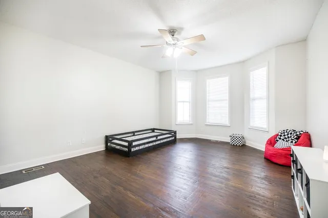 a view of room with hardwood floor and ceiling fan