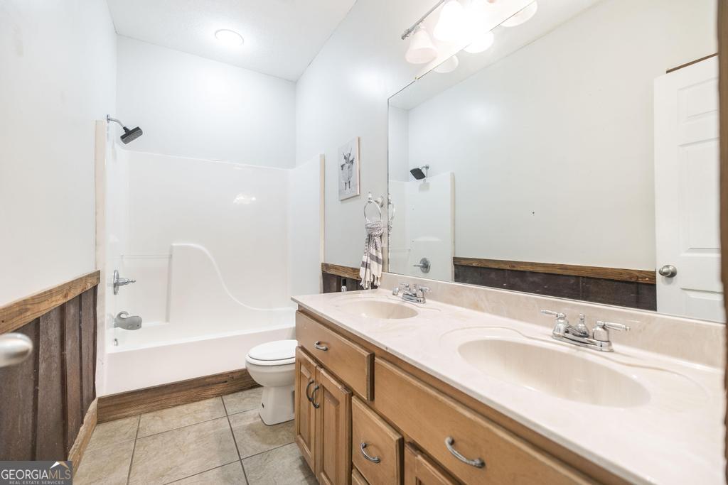119 William D Street Cochran, GA 31014 - Photo 24 of 42 a bathroom with a granite countertop sink mirror vanity and toilet