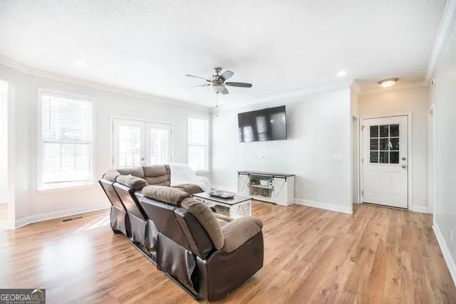 a living room with furniture and a wooden floor