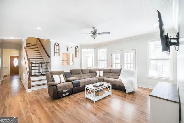 a living room with furniture and a wooden floor