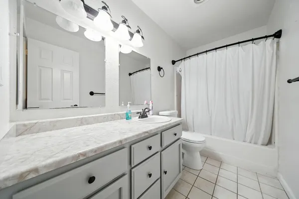 a bathroom with a granite countertop sink a toilet and a mirror