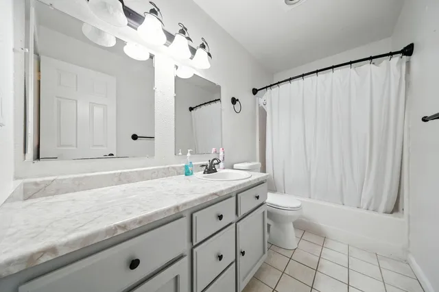 a bathroom with a granite countertop sink a toilet and a mirror