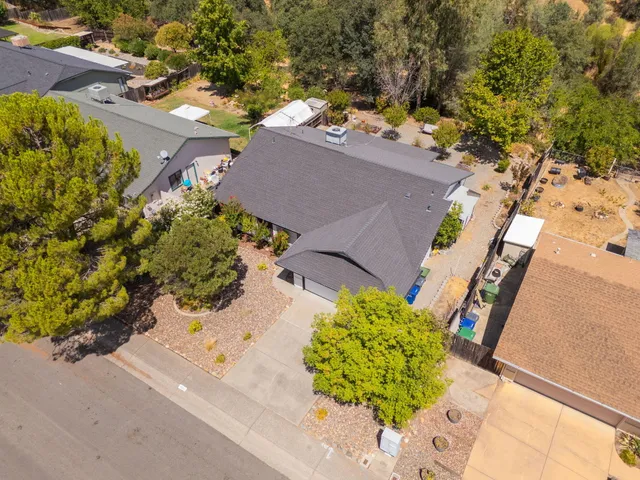 an aerial view of a house with a yard and a large tree