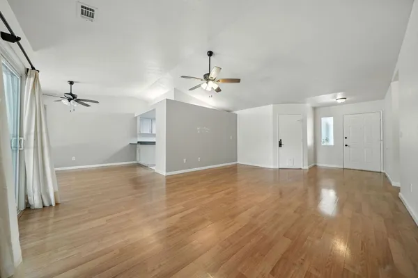 a view of a livingroom with a ceiling fan window and wooden floor