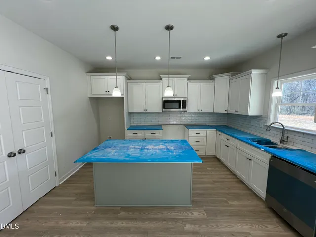 a large kitchen with kitchen island a sink stainless steel appliances and cabinets