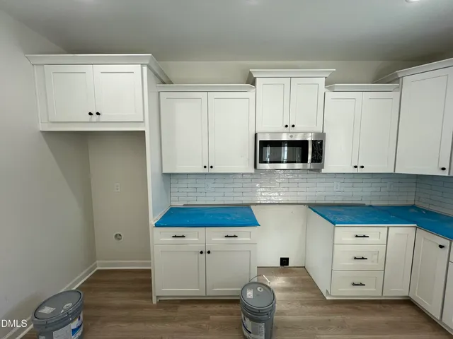 a kitchen with white cabinets and stainless steel appliances