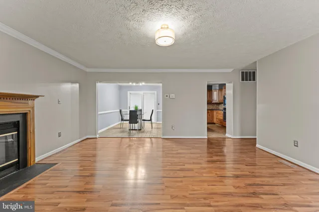 a view of empty room with wooden floor and fireplace