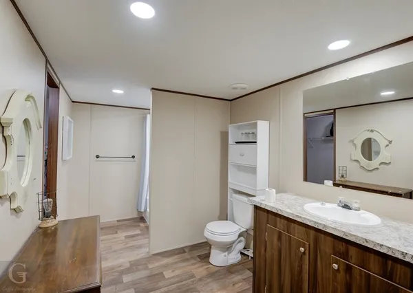 a bathroom with a granite countertop sink toilet and shower
