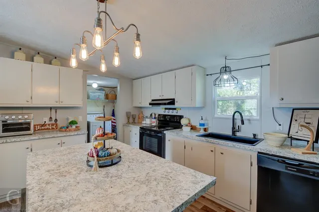 a kitchen with a sink a stove and cabinets