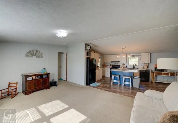 a living room with furniture and a kitchen view