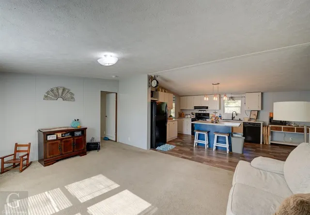 a living room with furniture and a kitchen view