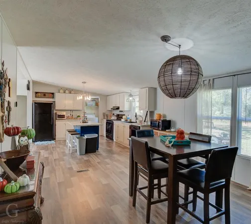 a dining room with furniture a chandelier and wooden floor