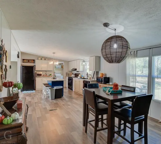 a dining room with furniture a chandelier and wooden floor