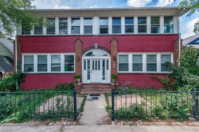 a front view of a building with a garden