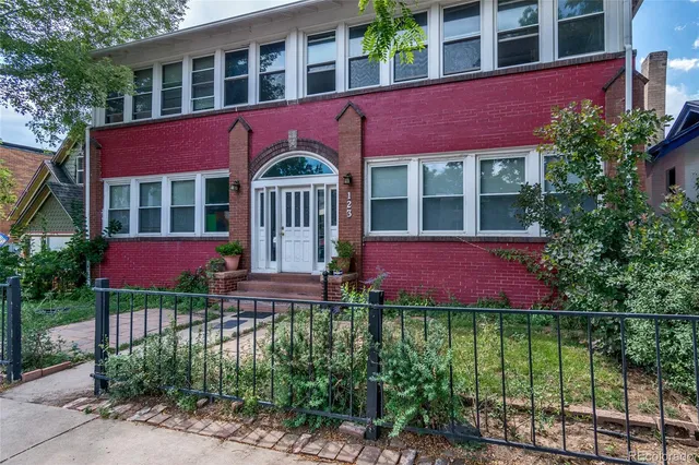 a front view of residential houses with yard and green space