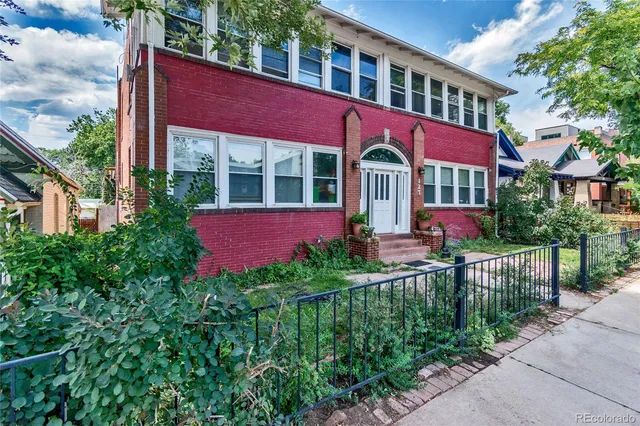a view of a house with brick walls and flower plants
