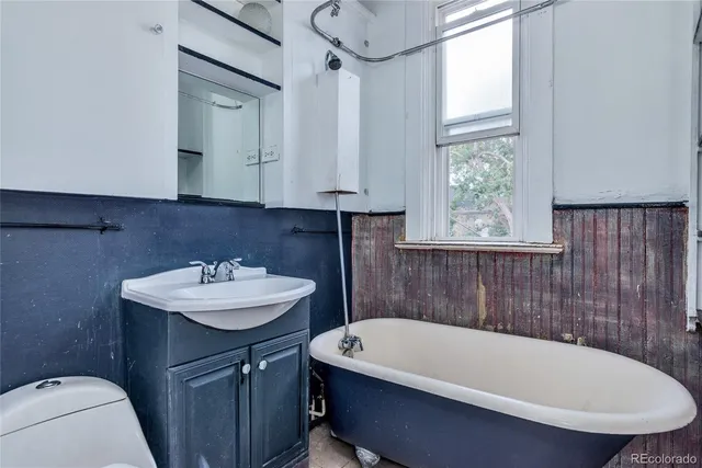 a bathroom with a sink a toilet a mirror and tub