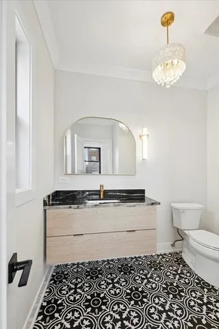 a bathroom with a granite countertop sink a toilet and a mirror