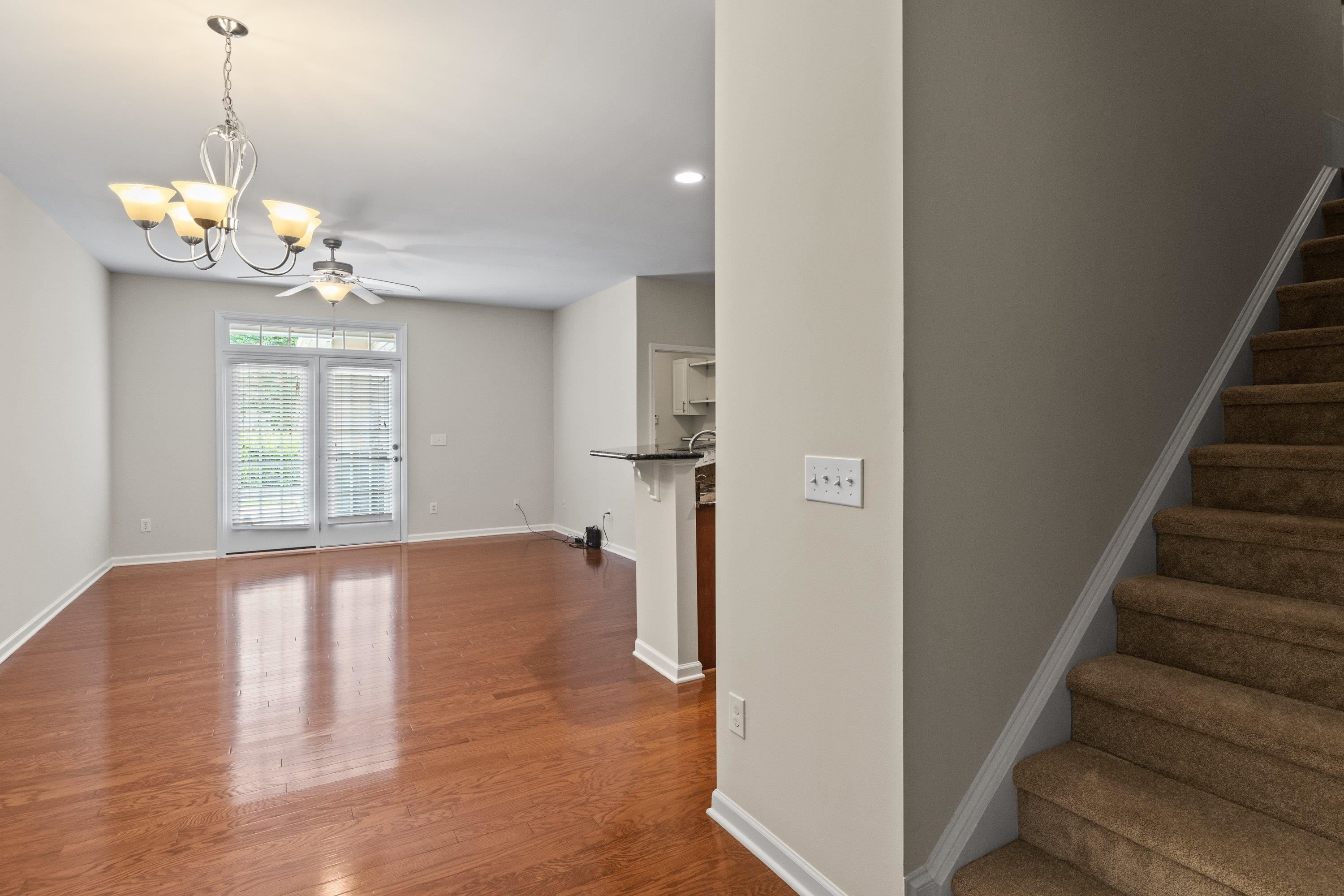 1369 Still Monument Way Raleigh, NC 27603 - Photo 5 of 46 a view of an empty room with wooden floor and kitchen view