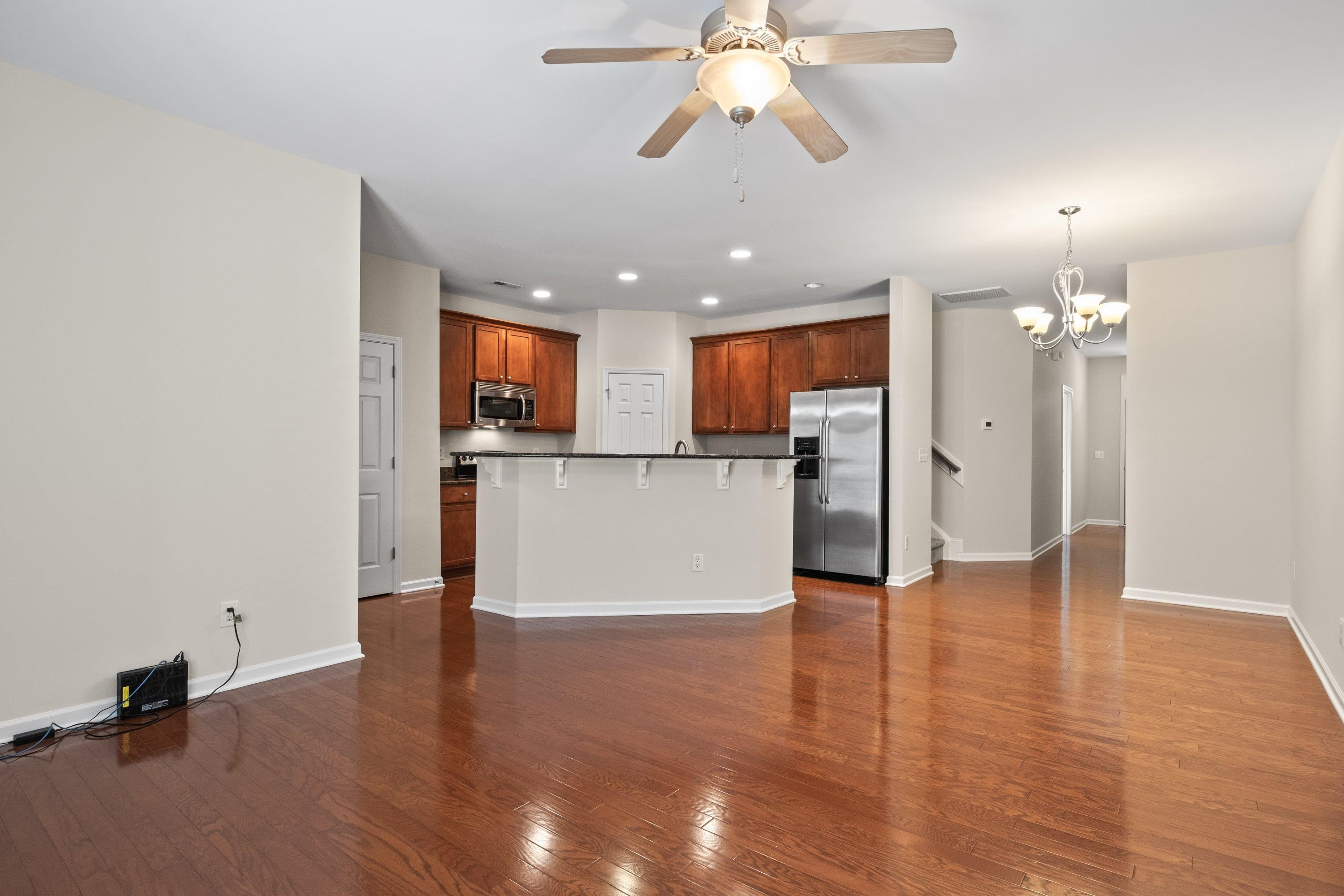 1369 Still Monument Way Raleigh, NC 27603 - Photo 8 of 46 a view of a kitchen with a refrigerator wooden floor and a chandelier