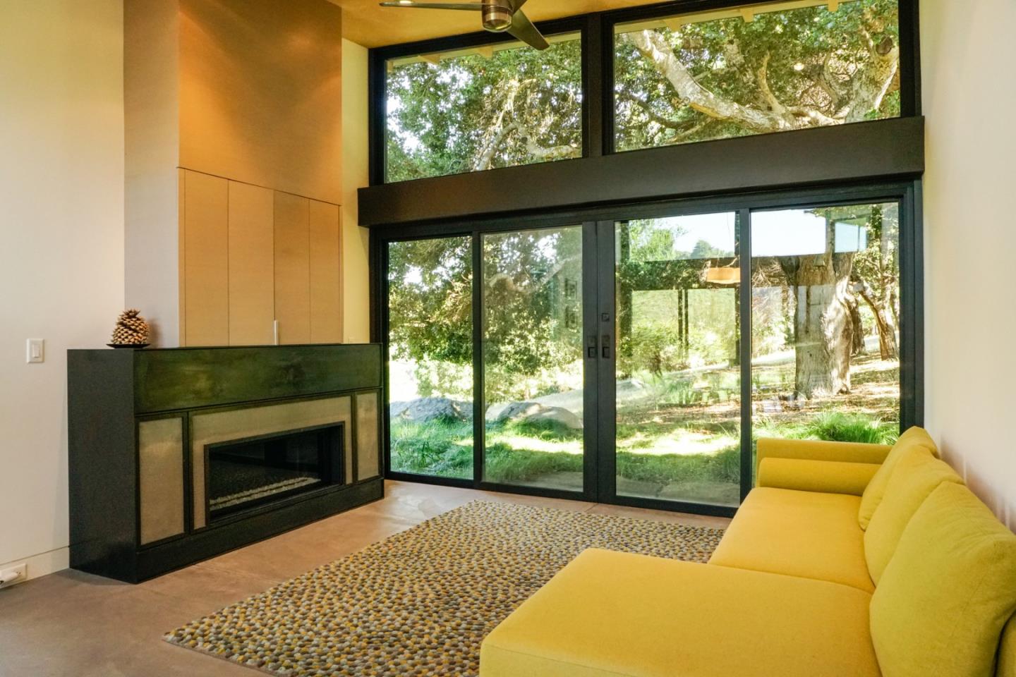 1 Goodrich Trail Carmel, CA 93923 - Photo 46 of 50 a living room with furniture a fireplace and floor to ceiling windows