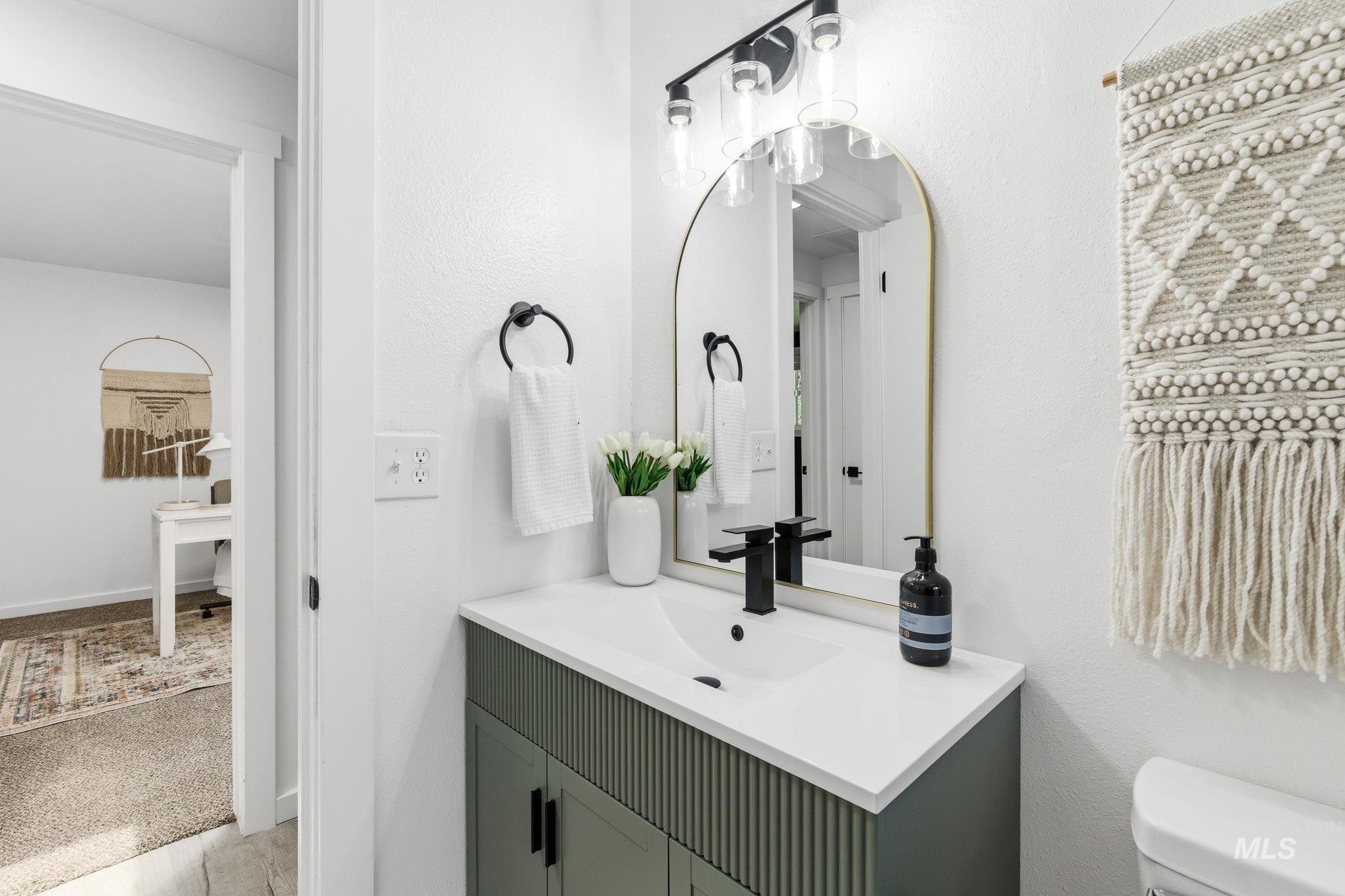 2224 Rachel Circle Boise, ID 83706 - Photo 34 of 50 Contemporary bathroom vanity featuring a solid surface countertop with an integrated sink, matte black faucet, and a fluted-front cabinet base